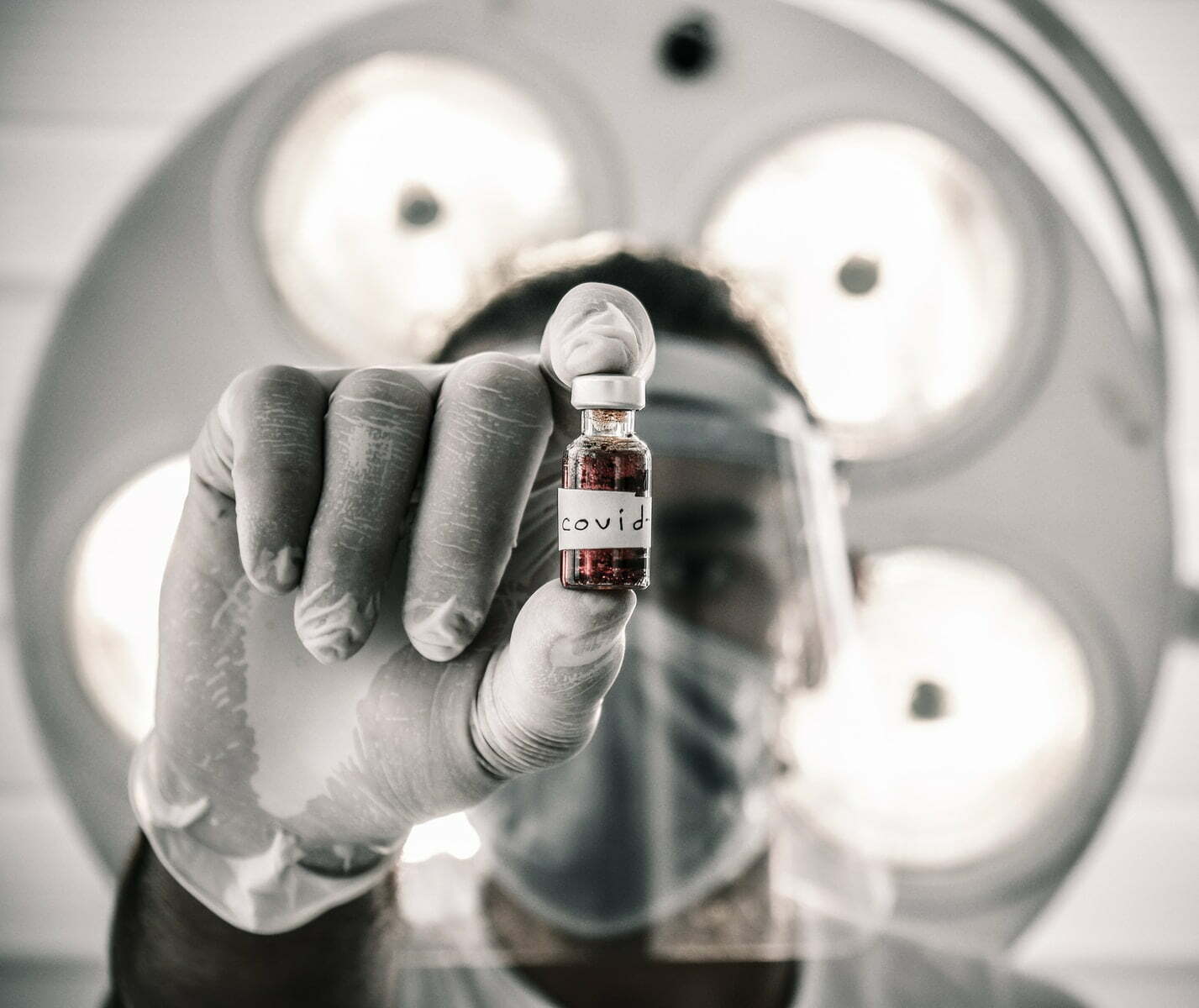 person holding white and red labeled bottle
